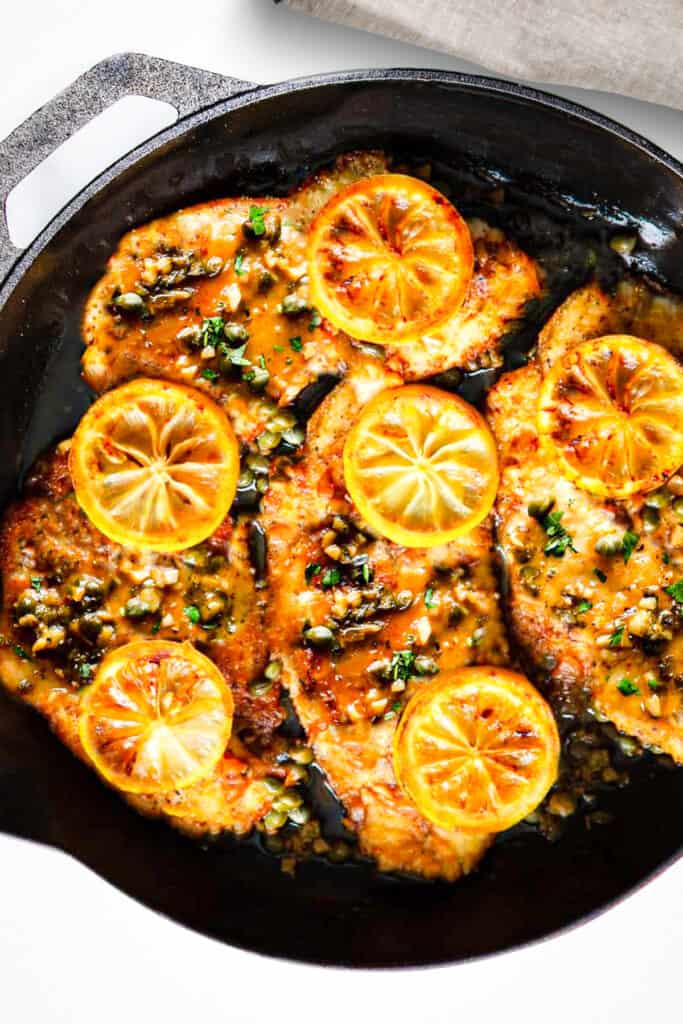 el pescado con la salsa y rodajas de limón