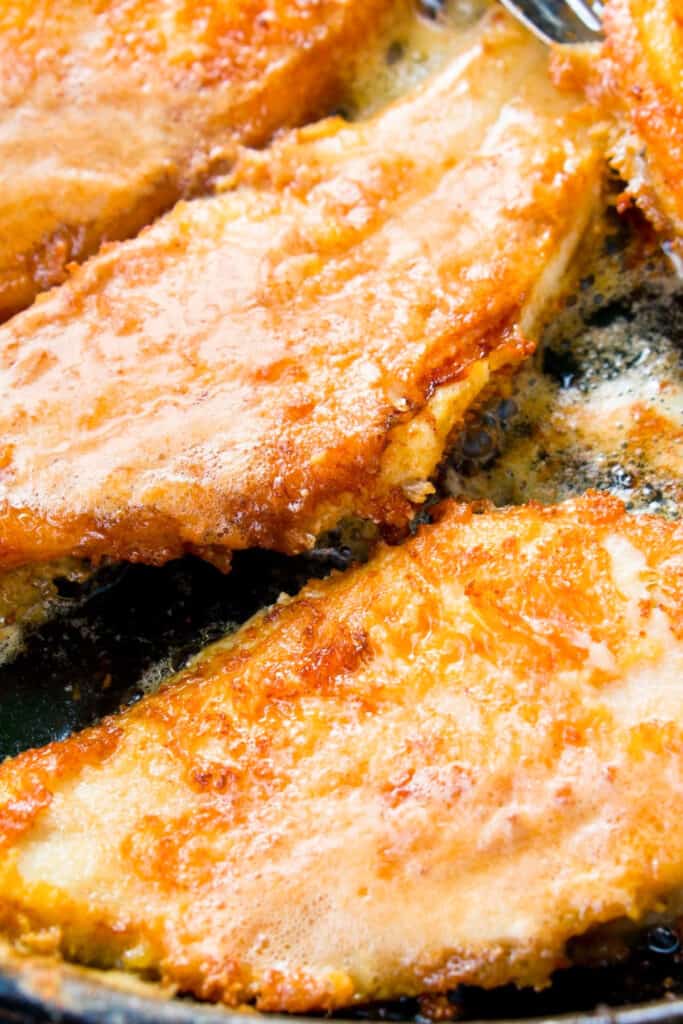 breaded fish frying in a pan