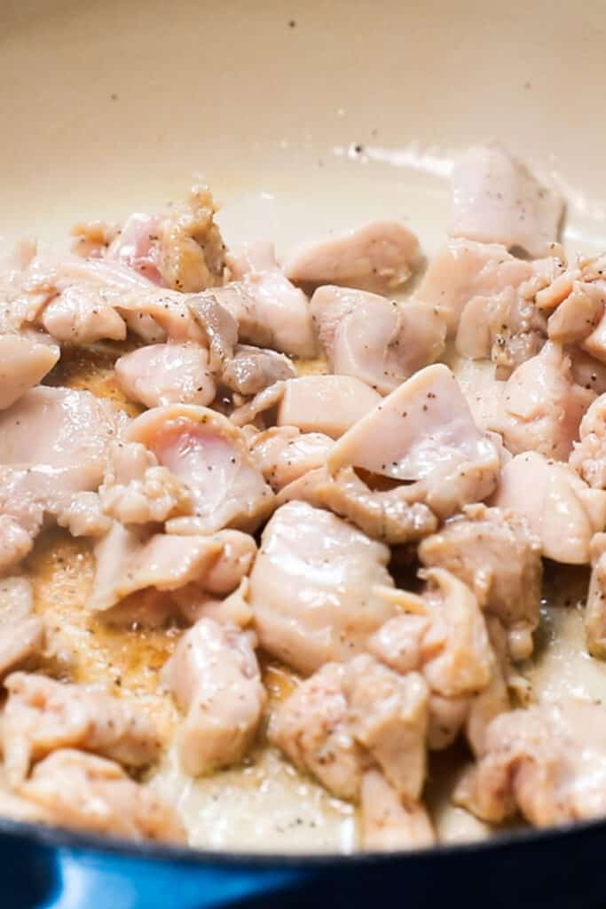 chicken pieces cooking in a pan