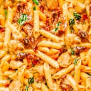 A close up image of Chicken, Sundried Tomatoes, and pasta in a creamy sauce