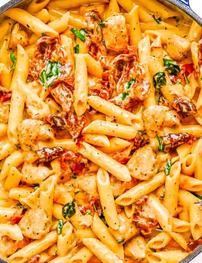 A close up image of Chicken, Sundried Tomatoes, and pasta in a creamy sauce