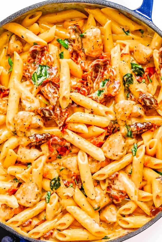 A close up image of Chicken, Sundried Tomatoes, and pasta in a creamy sauce