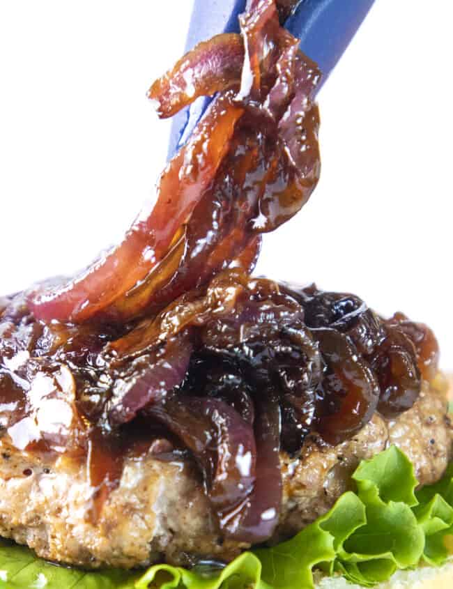 burger onions being placed on a burger