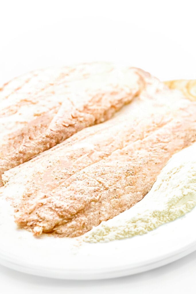 fish coated in flour on a plate.