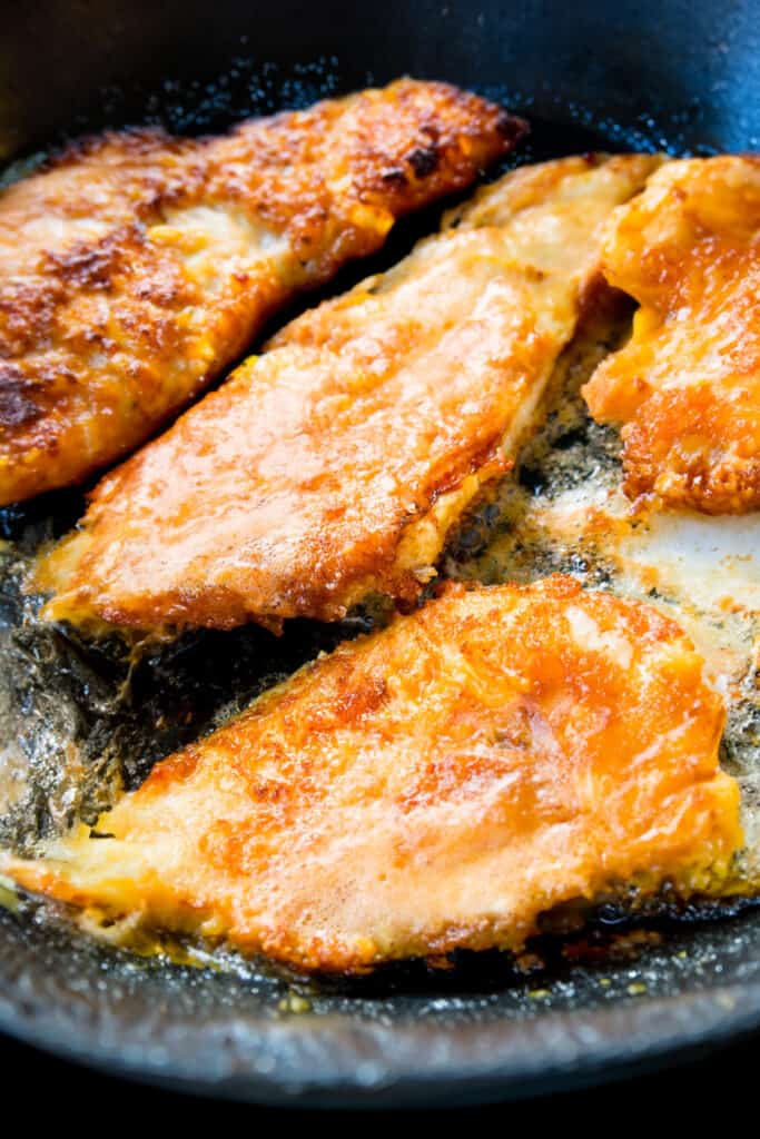 breaded fish frying in a pan