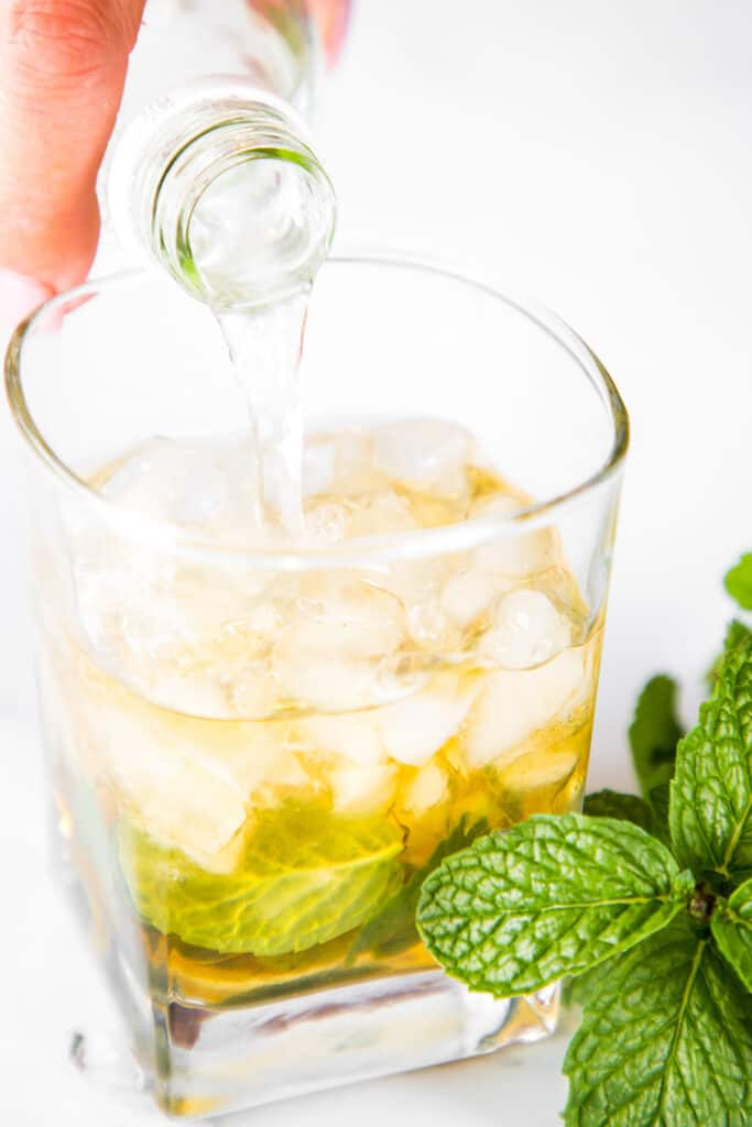 tonic water being poured into the Mint Julep Cocktail