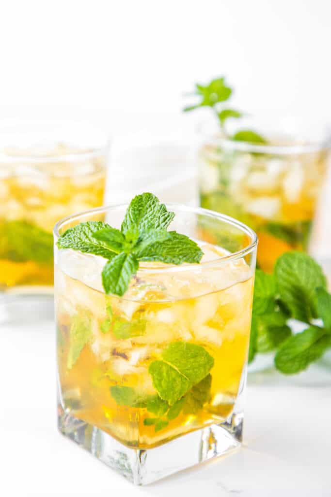 three glasses of Mint Julep Cocktail garnished with a sprig of mint