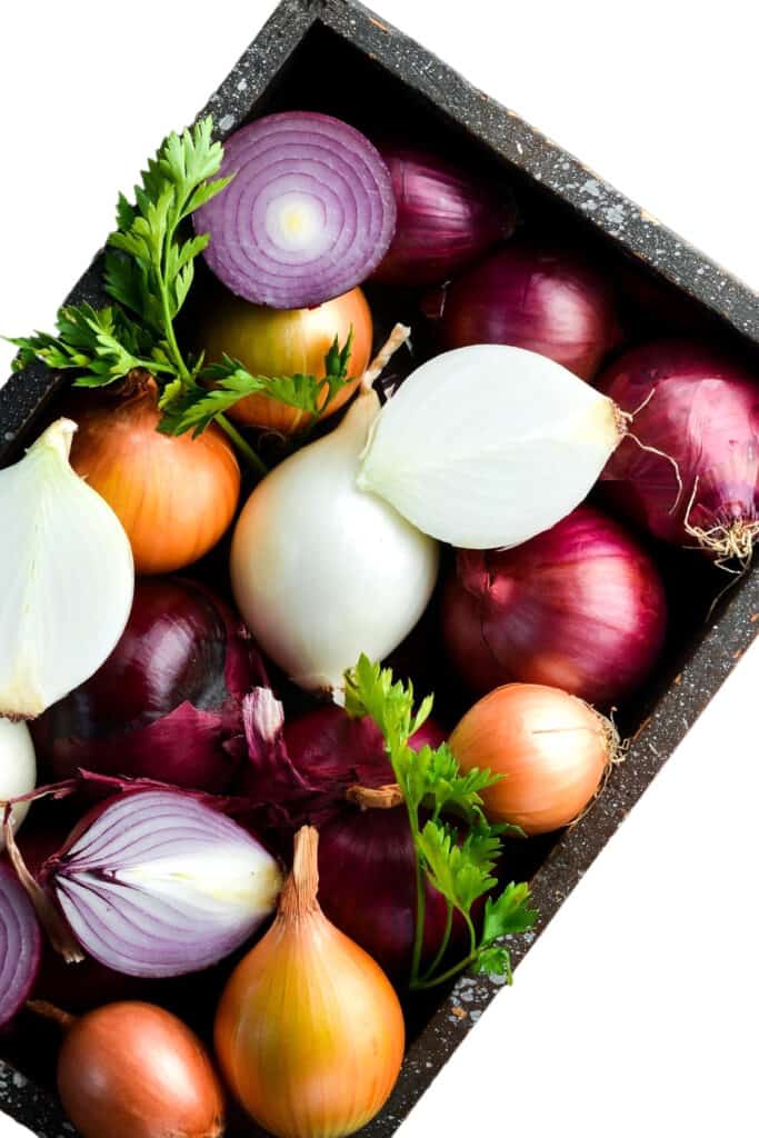 una caja de cebollas rojas, amarillas y blancas