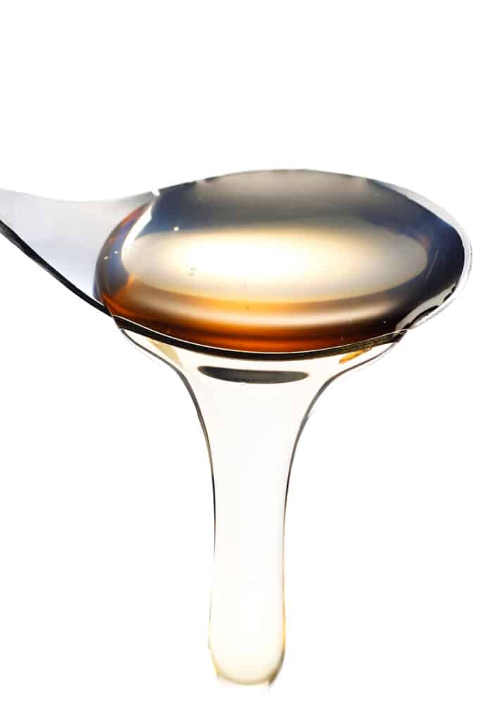 a spoon pouring simple syrup