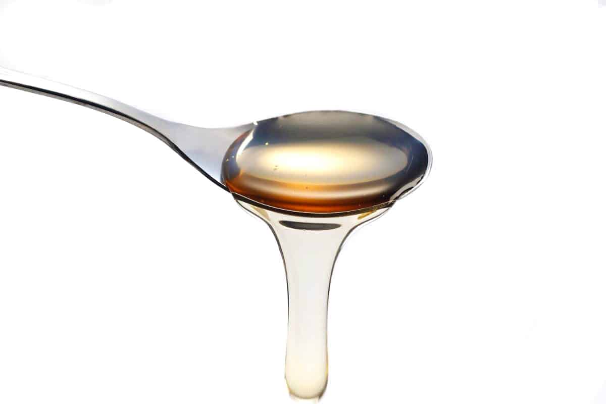 a spoon with simple syrup pouring from it