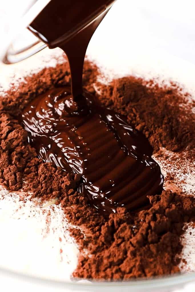 melted chocolate being added to the bowl with the other ingredients