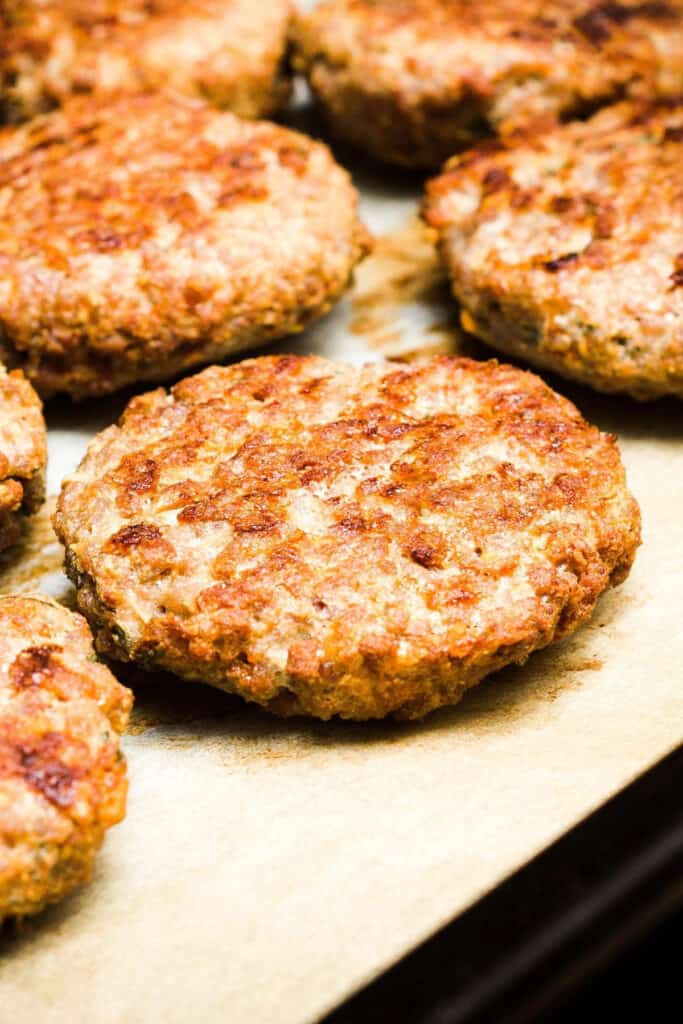 baked pork burgers on a baking tray