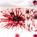 an over head shot of cherry semifreddo topped with cherry jam and fresh cherries and a jam covered spoon