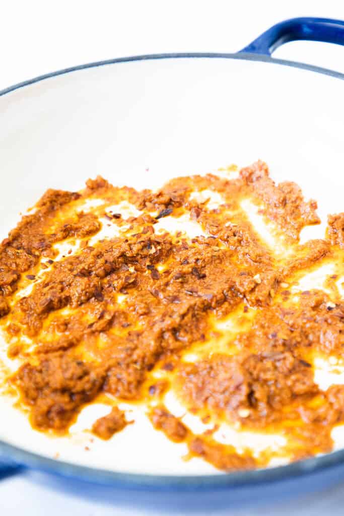 res pesto, garlic and pepper flakes cooking in a pan