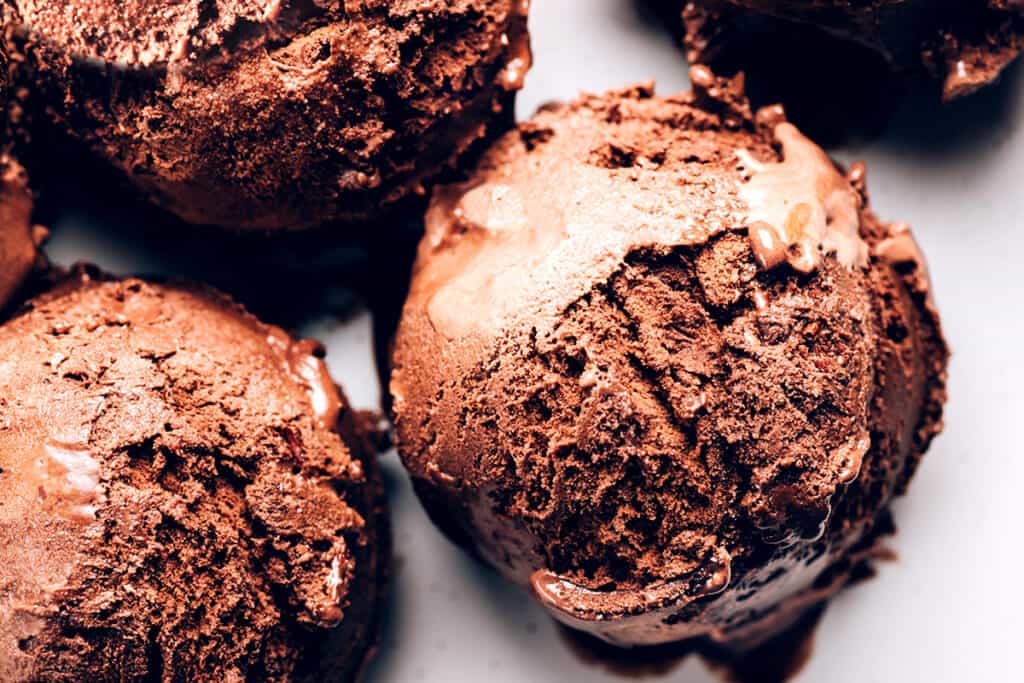 scoops of dark chocolate ice cream on a white plate