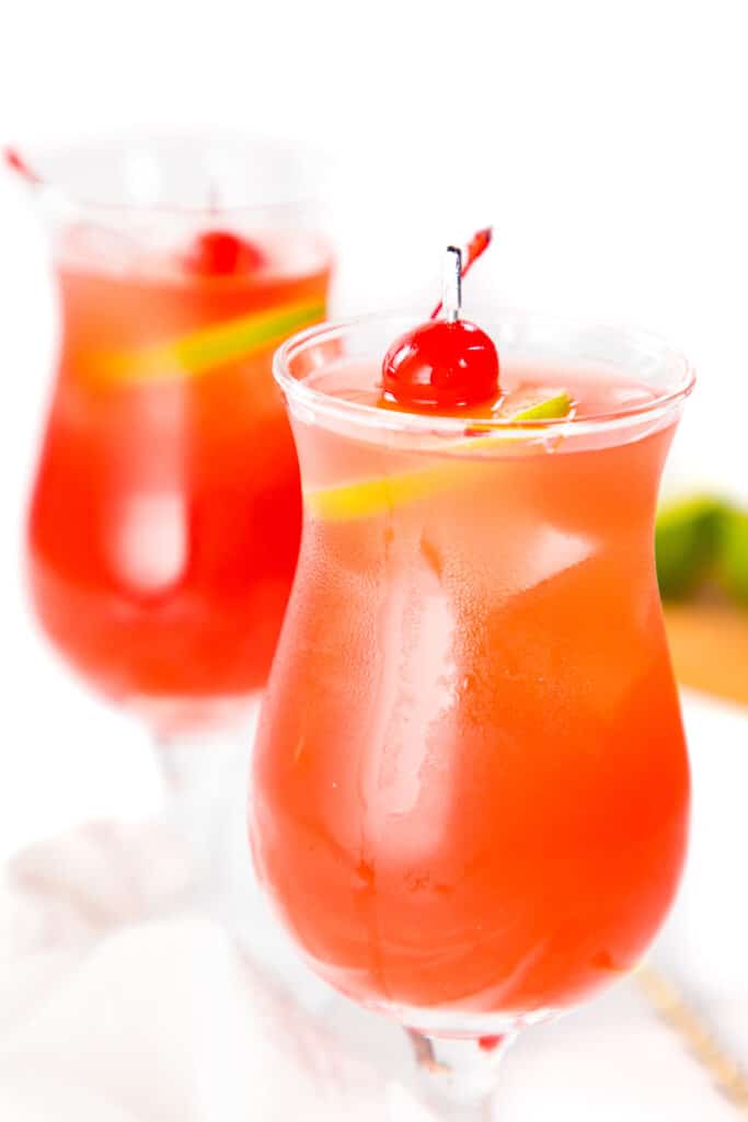 two sea breeze cocktails garnished with a lime slice and maraschino cherry