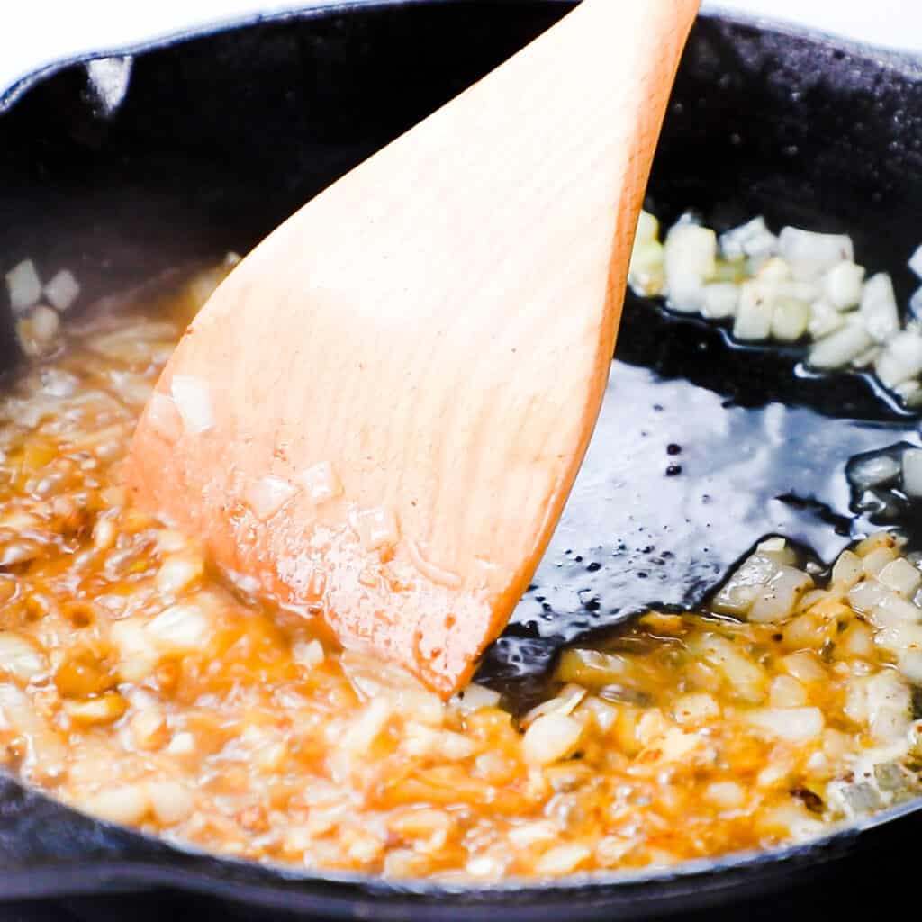 water added to the pan with the onions and garlic
