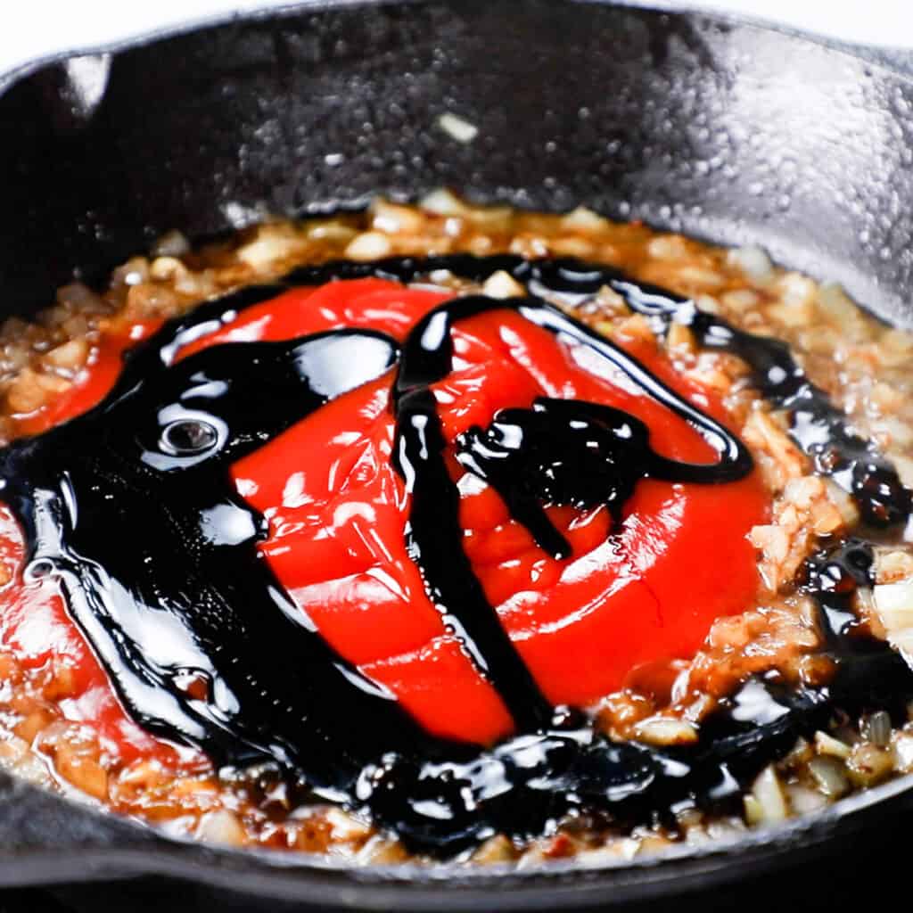 Ketchup, molasses, and soy saice in the pan with the beans mixture
