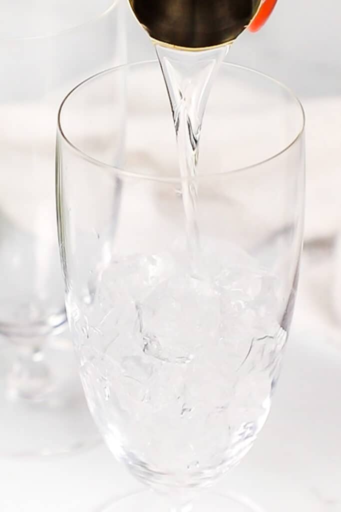 adding vodka to a glass with ice