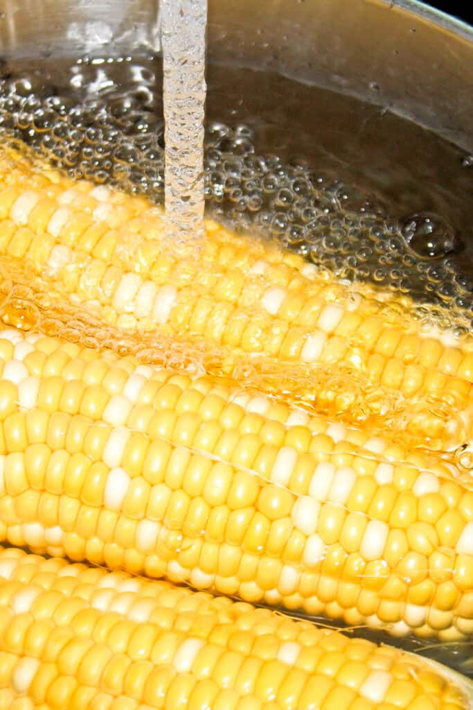 water running over corn on the cob in a bowl