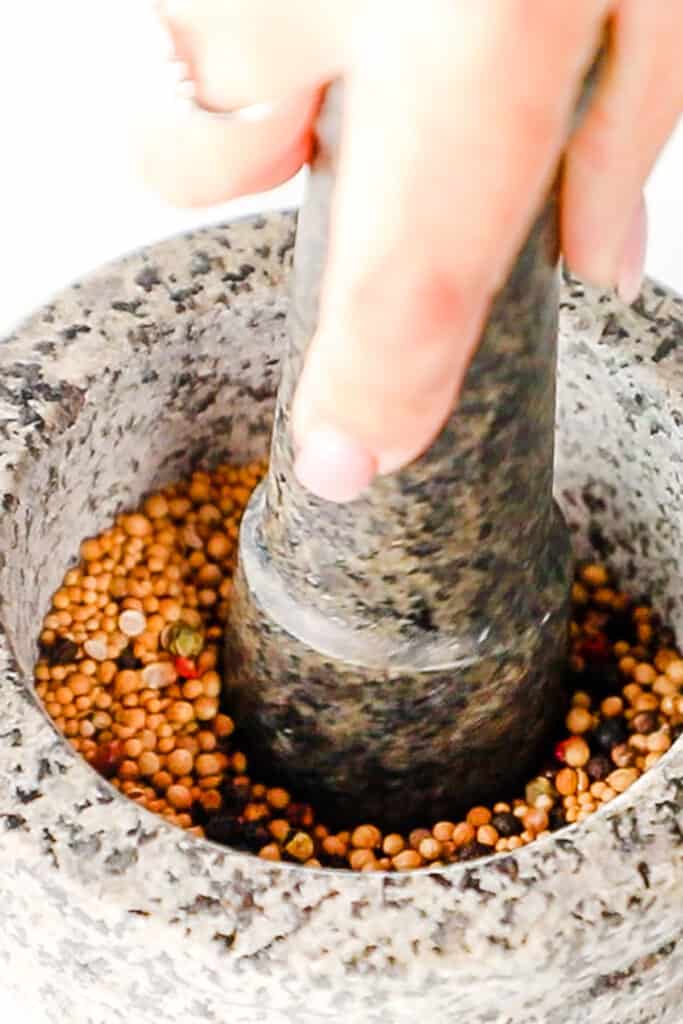spices being crushed with a mortar and pestle