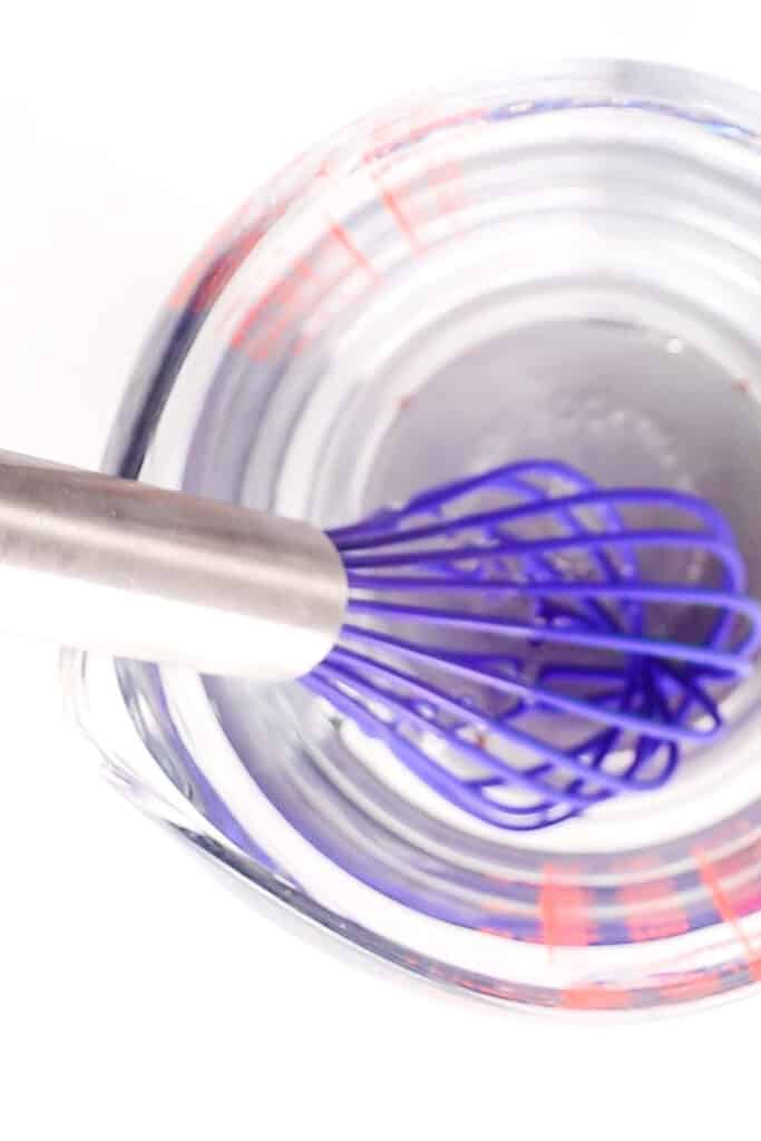 the water mixture in a jug with a whisk