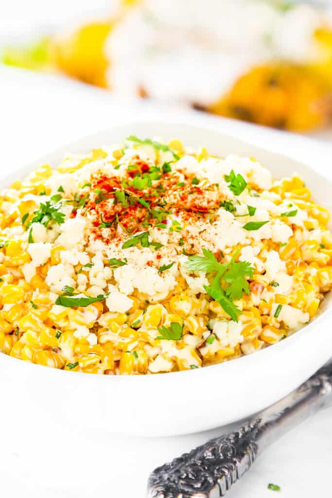 a bowl of Mexican Street Corn topped with cheese and spices