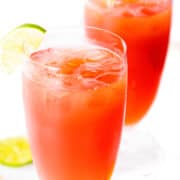 two glasses of two bay breeze cocktail with a lime wedge on the glass