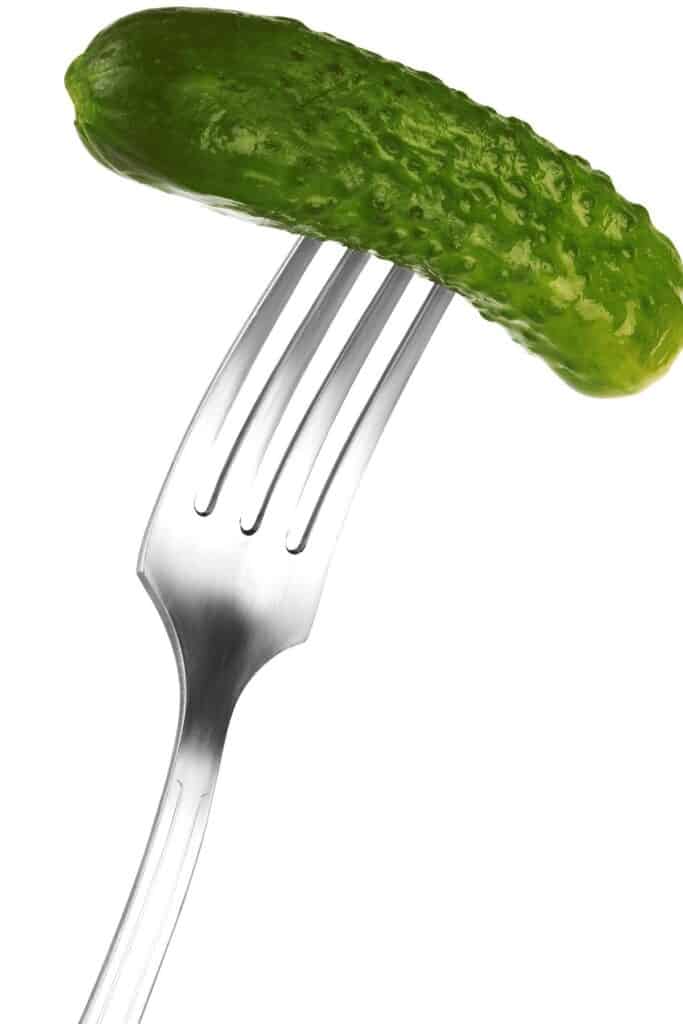 un pepinillo entero en el extremo de un tenedor