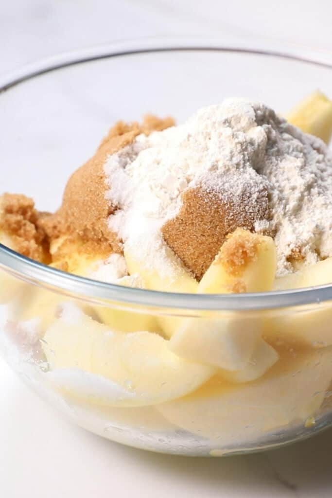 dry ingredients added to the bowl with the apples