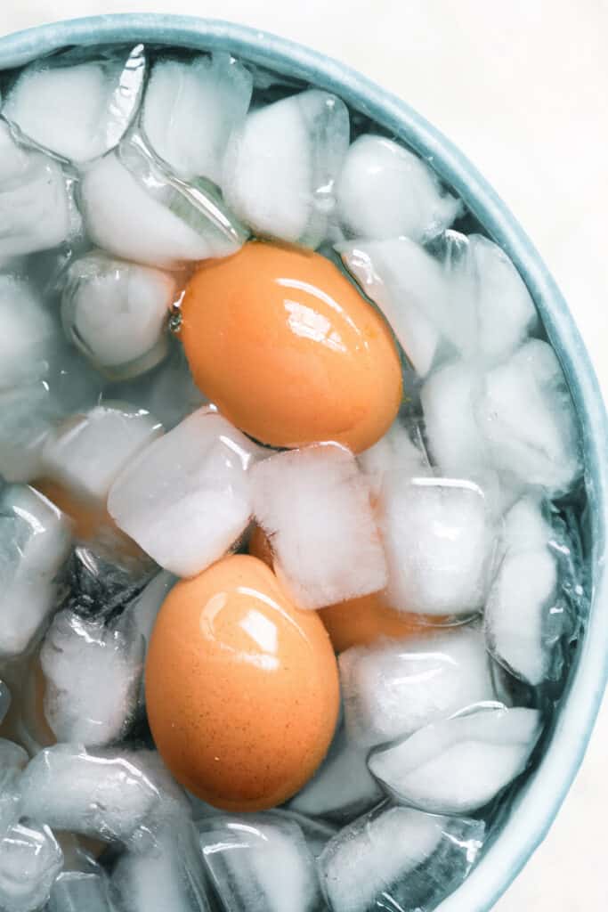 cooked eggs in a bowl of ice water