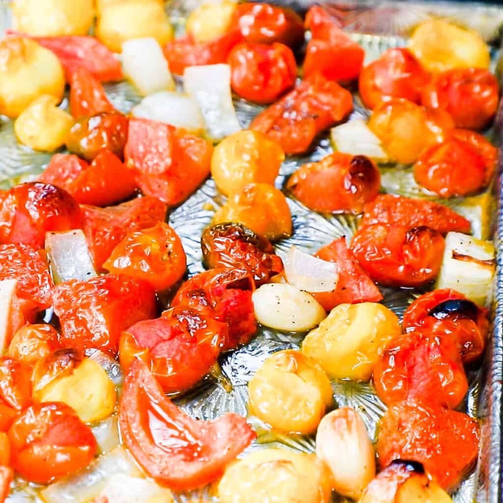 roasted tomatoes, onions and garlic on a sheet pan