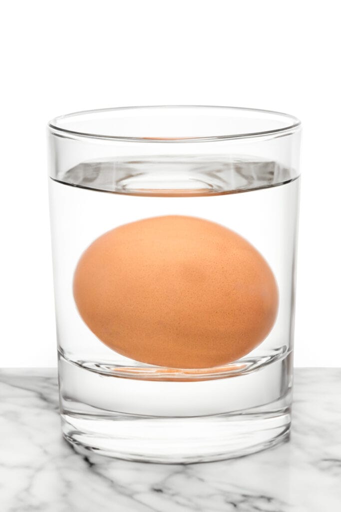 a glass of water with an egg in it