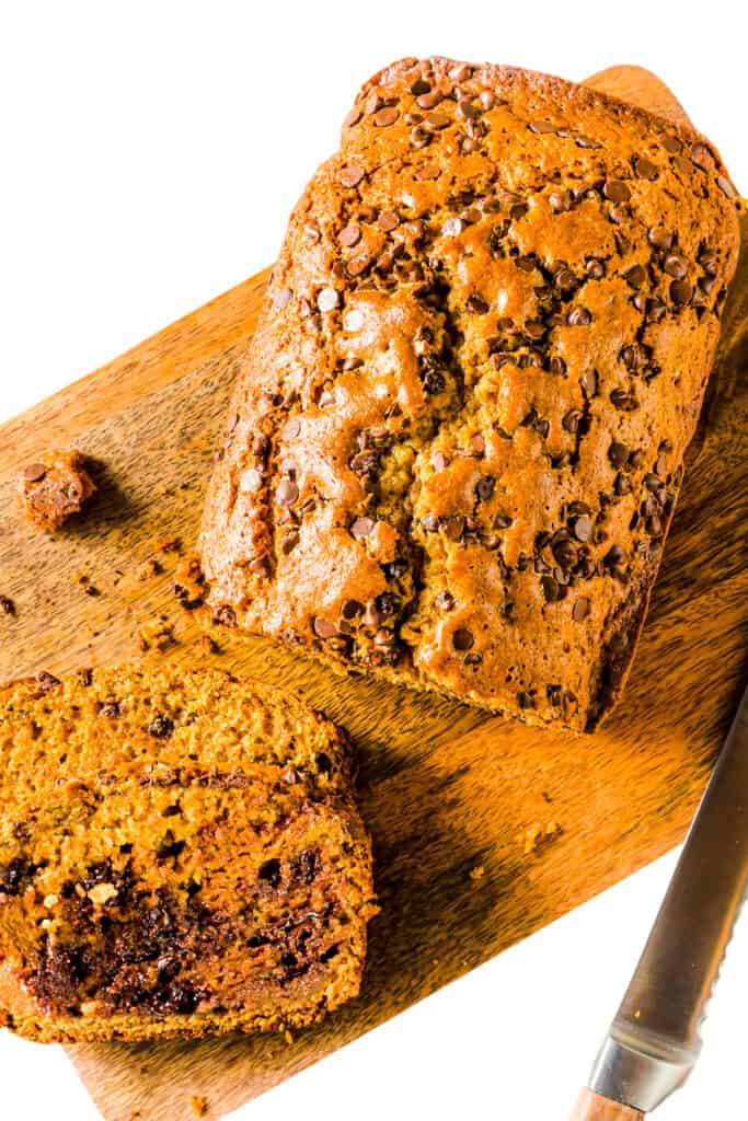 A loaf of Easy Pumpkin Bread with a couple of slices next to it.