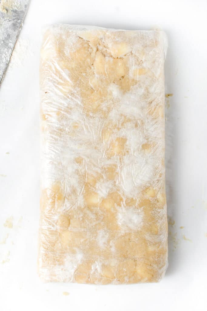 the dough wraped in plastic showing clumps of butter in it