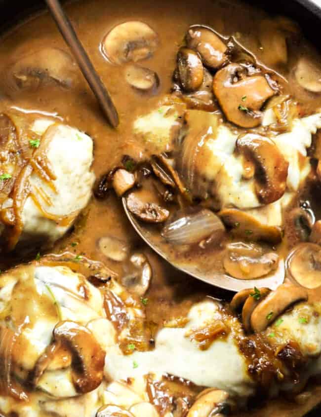 Smothered Pork Chops covered with white cheese in a mushroom gravy