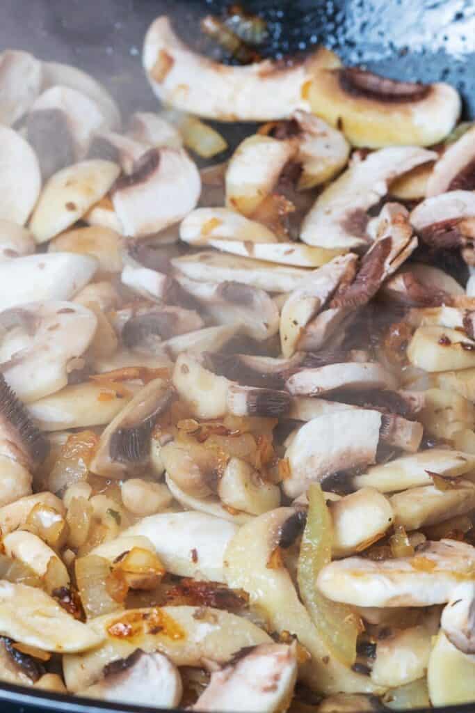 The mushrooms added to the pan with the onions.