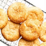 Snickerdoodles stacked on a cooling rack.