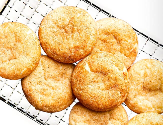snickerdoodles stacked on a cooking rack