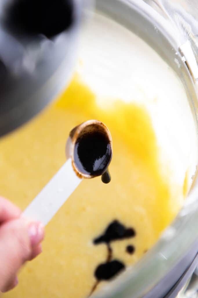 the vanilla bean paste being added to the butter mixture
