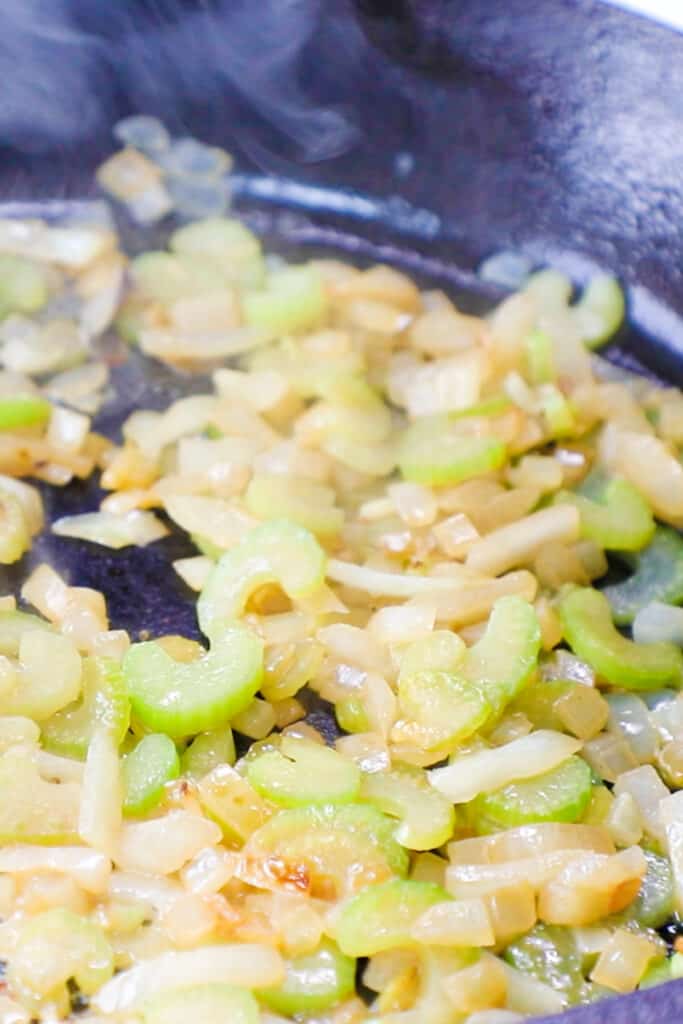 Onions and celery cooking in butter in a frying pan