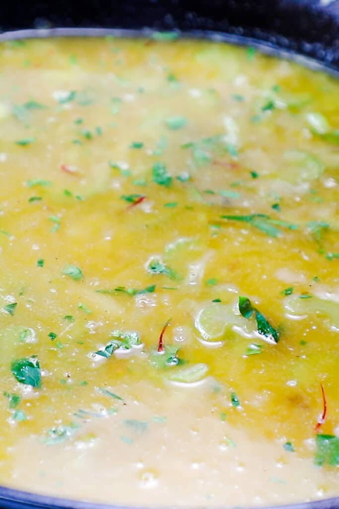 The stock and saffron added to the pan with the parsley.