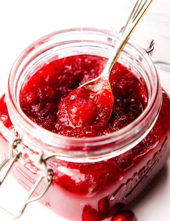 Homemade Fresh Cranberry Sauce in a jar with a spoon