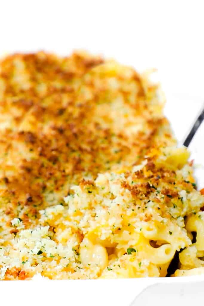 a dish full of Creamy Baked Mac and Cheese with a serving spoon