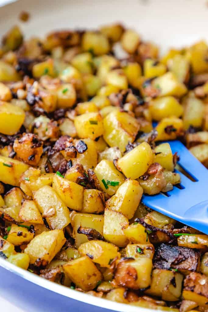 Fried Potatoes and Onions in a pan with a spatula