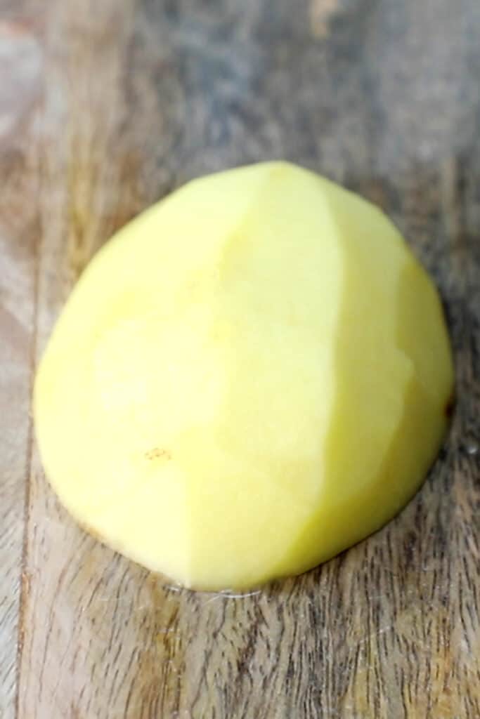 a potato cut in hald on a chopping board