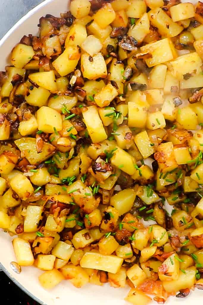the Fried Potatoes and Onions in a pan with chopped chives