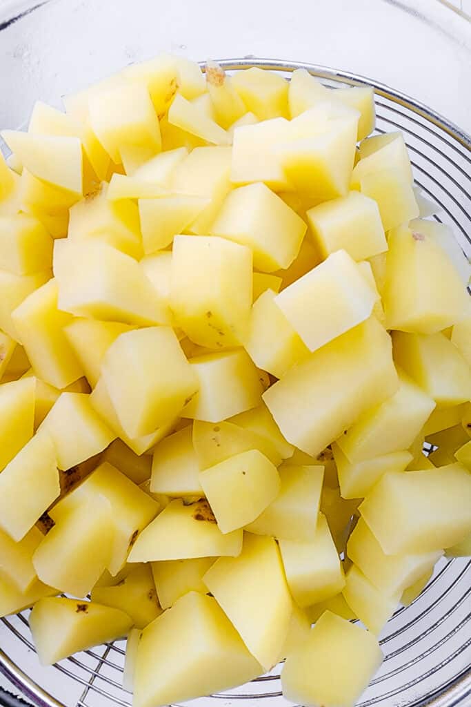 the drained poatoes in a strainer