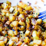 a close up image of Fried Potatoes and Onions in a skillet