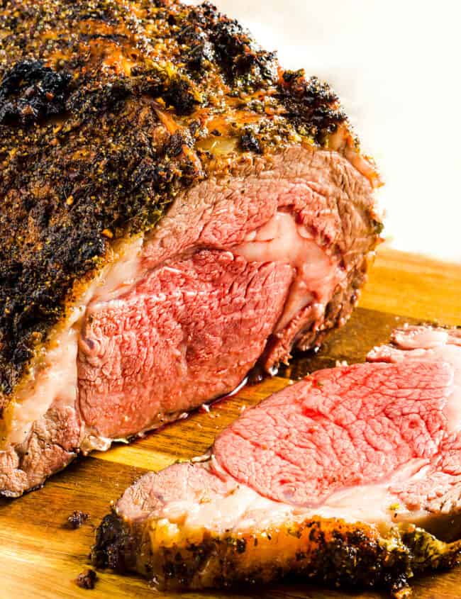 a Ribeye Roast {Boneless Prime Rib} on a cutting board with a slice cut